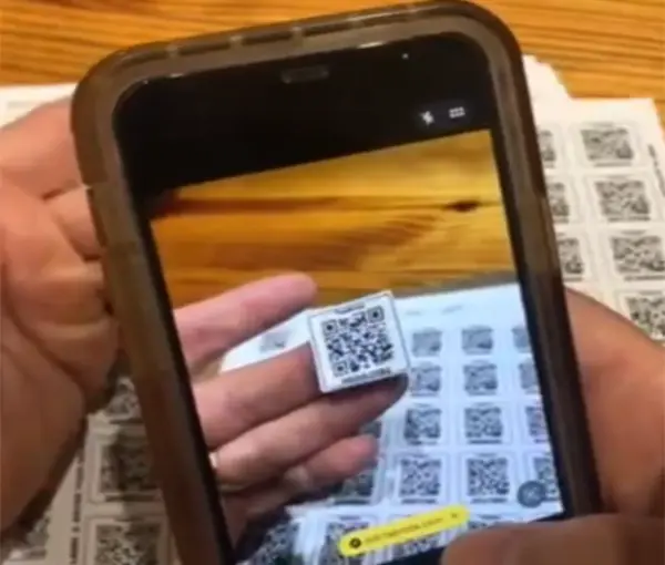 Phone scanning a TapNota QR label to activate an entire smart QR label pack